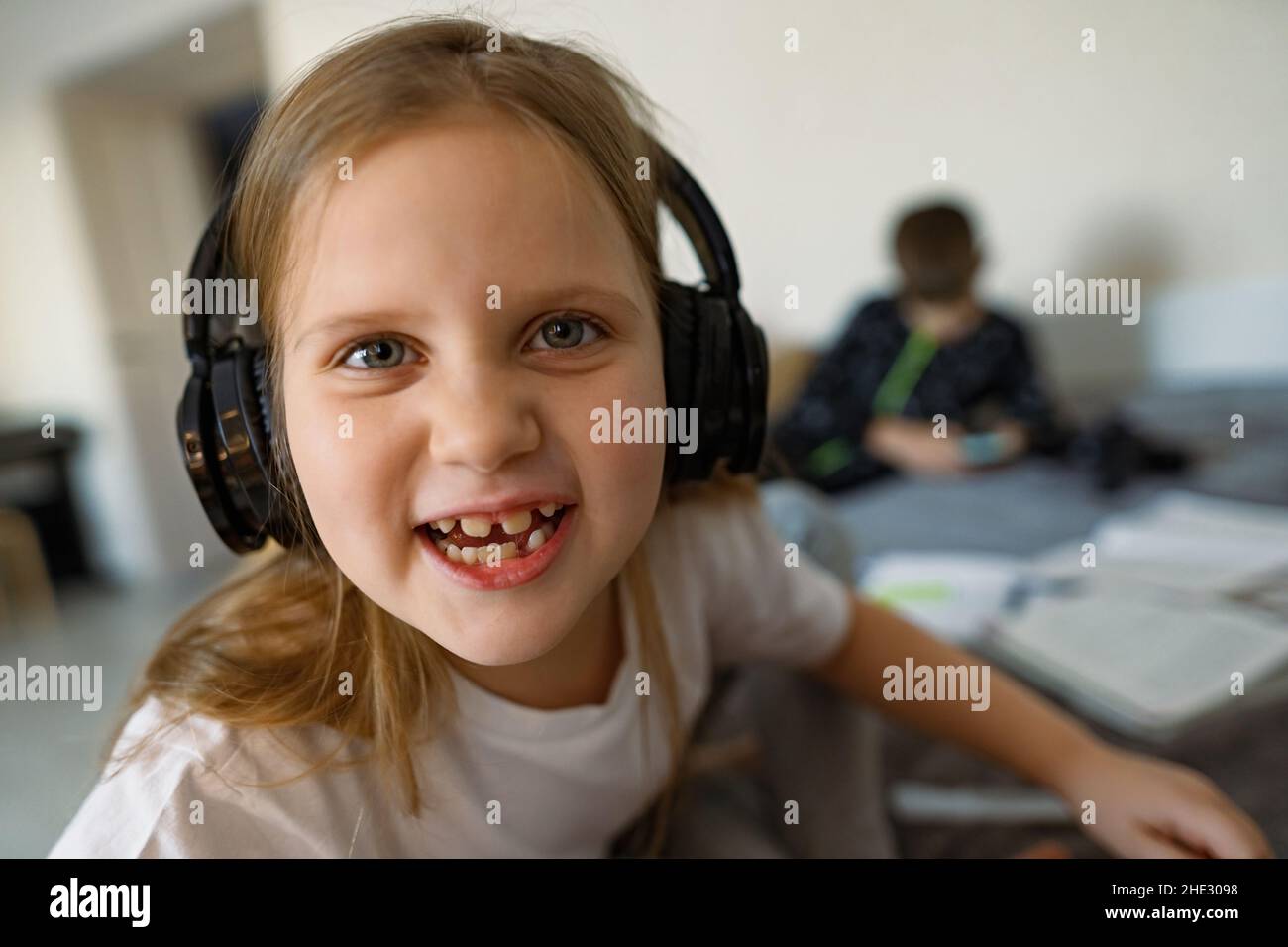 Ggirl in big headphones, smile, growing teeth are visible, fun Stock Photo
