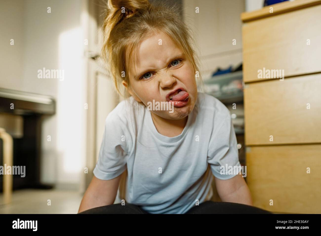 Girl 3-year old at home grimaces, makes faces Stock Photo