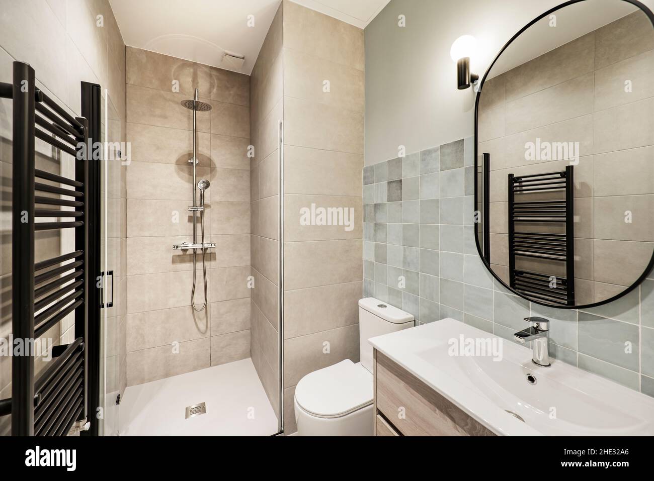 Modern toilet with shower, black towel radiator and sink Stock Photo