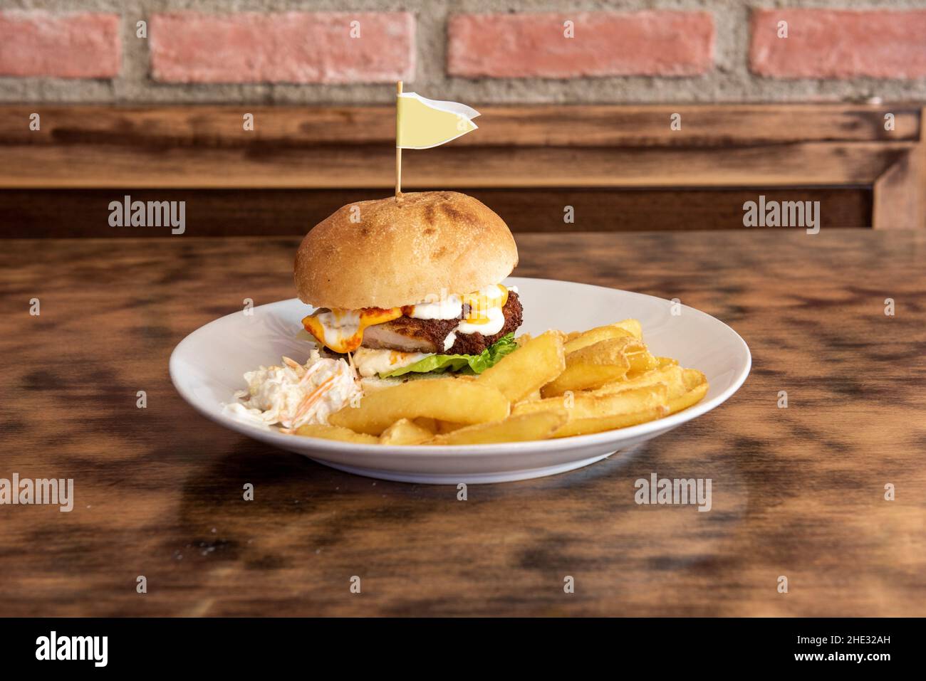 Fried chicken burger in batter with fried eggs and coleslaw with fries Stock Photo