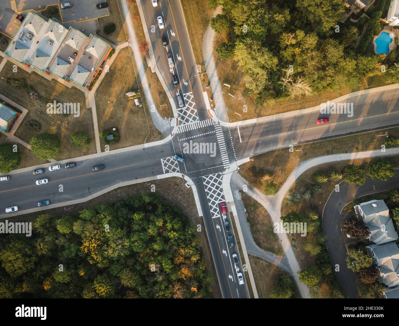 Top down aerial view of cars driving through intersection at sunset in