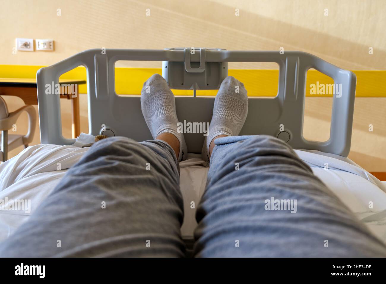 concept health and medicine: selfie of feet with white socks of a patient sitting in a hospital bed Stock Photo
