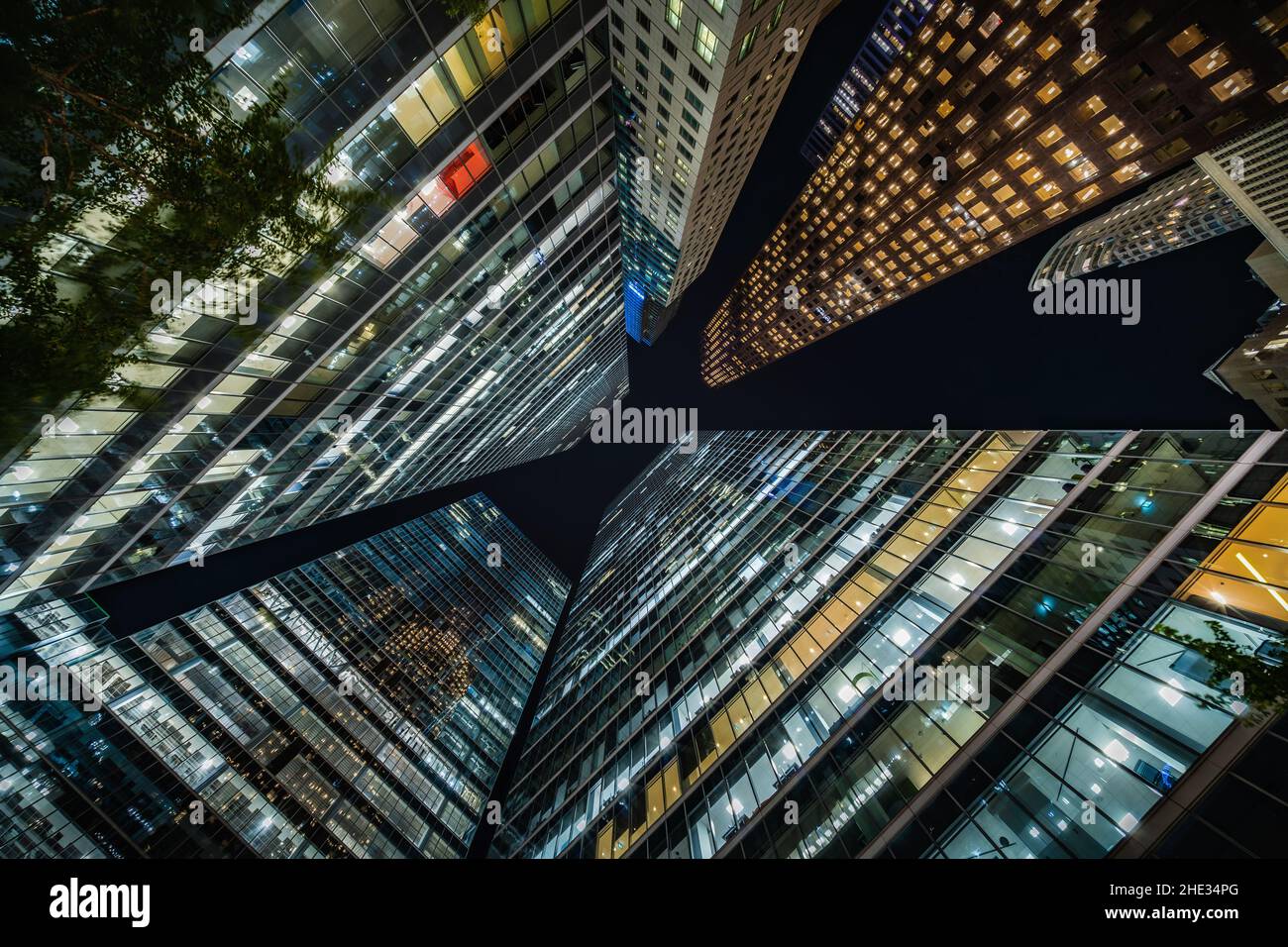 Business and finance concept, looking up at high rise office building architecture at night in the financial district of a modern metropolis. Stock Photo