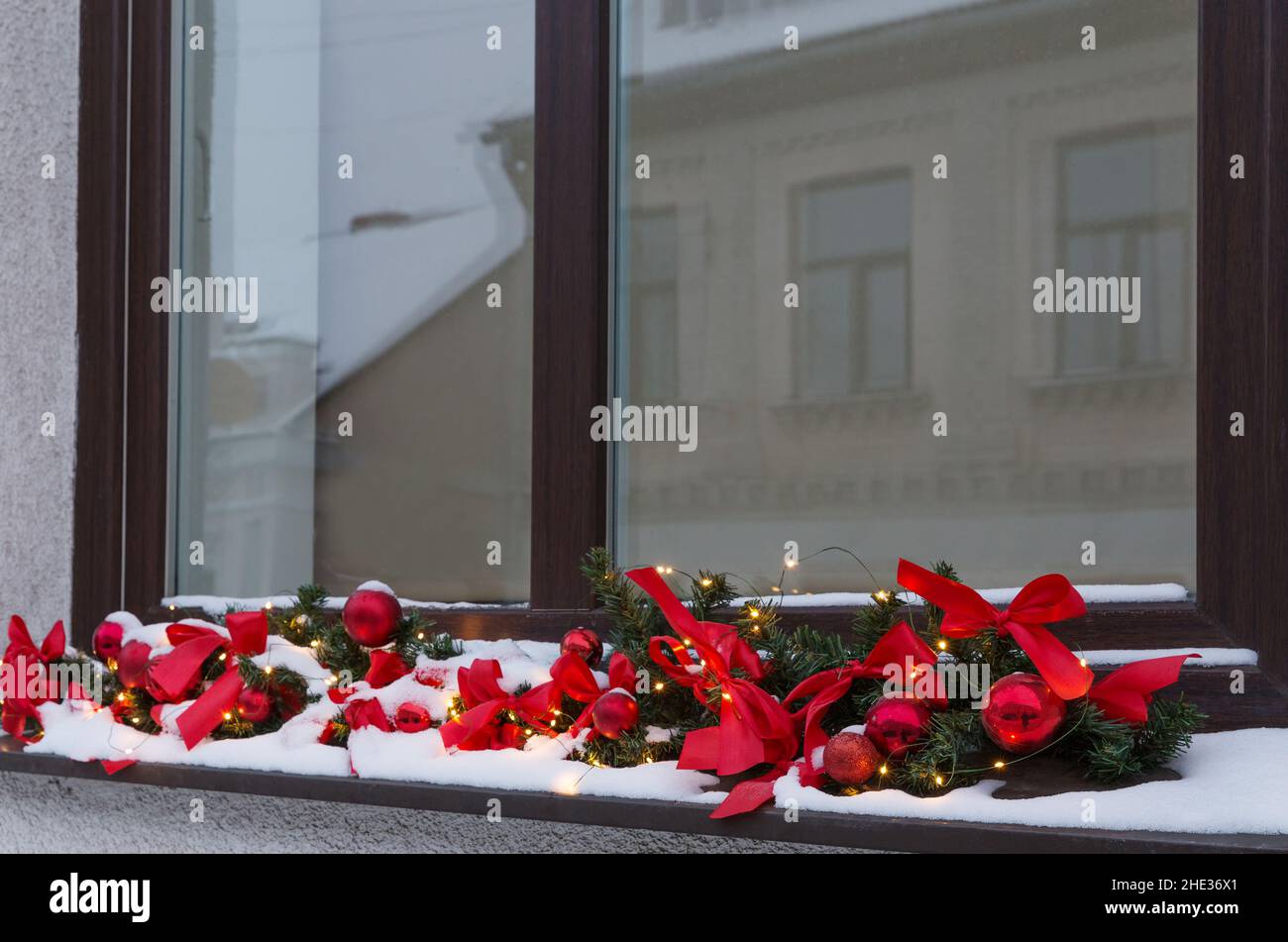 New year and christmas concept, decorated window with garlands of red ribbons and lights Stock Photo