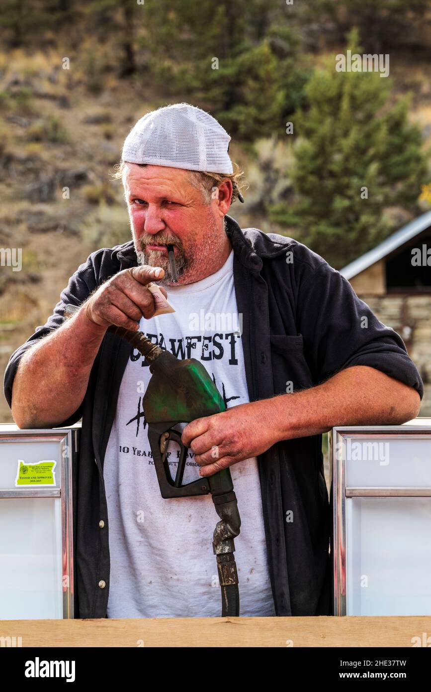 Junior, longtime Mitchell; Oregon; resident; offers a visitor a cocktail pumped from his outside gas station tap room; Mitchell; Oregon; USA Stock Photo