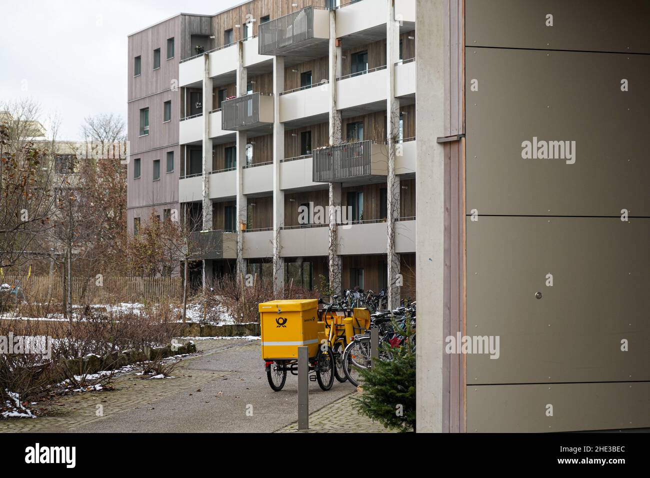 Bicycle of a DHL postal worker in front of a residential building. Stock Photo