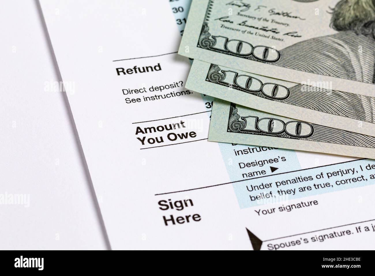 1040 individual income tax return form and money. Tax payment, filing taxes and financial planning concept. Stock Photo