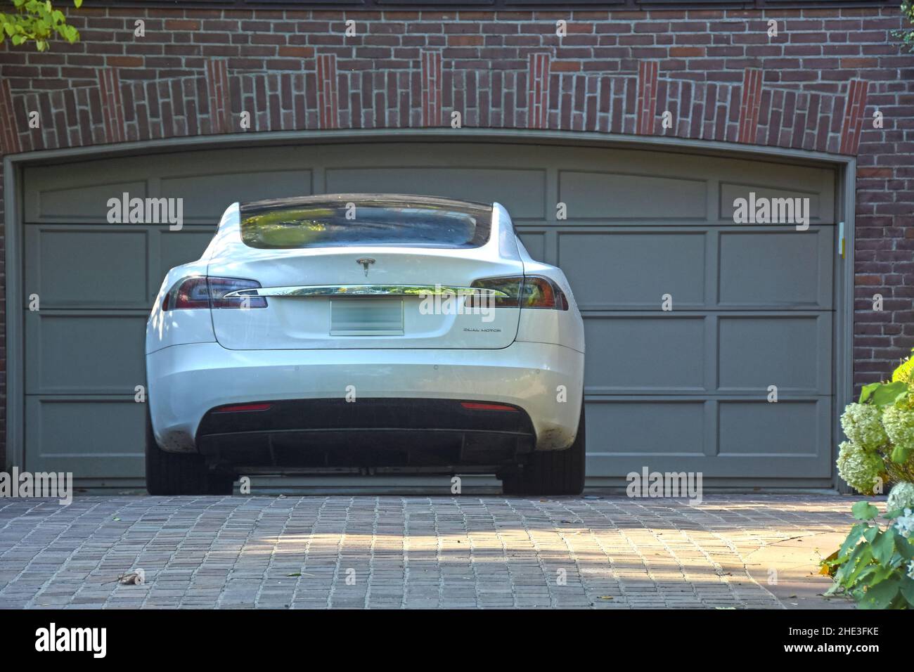 Tesla parking in front of a house garage Stock Photo Alamy