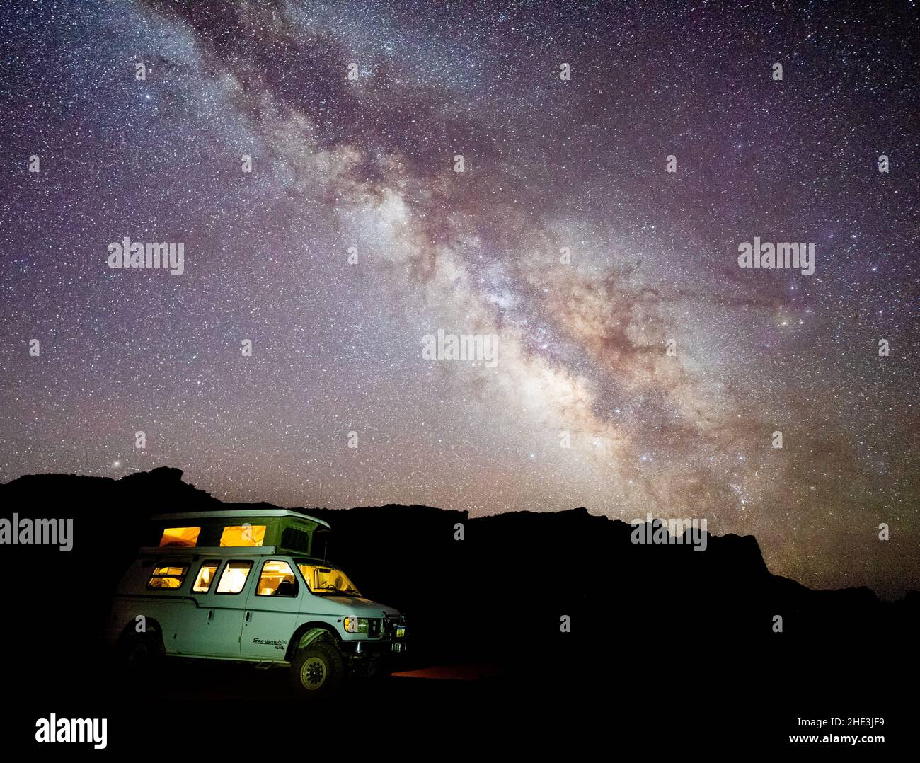 Milky Way above camper van with lights on while boondock camping off the Behind the Reef Road in