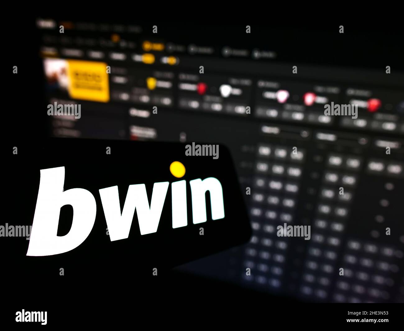 Smartphone with logo of Austrian company bwin Interactive Entertainment AG on screen in front of business website. Focus on left of phone display. Stock Photo