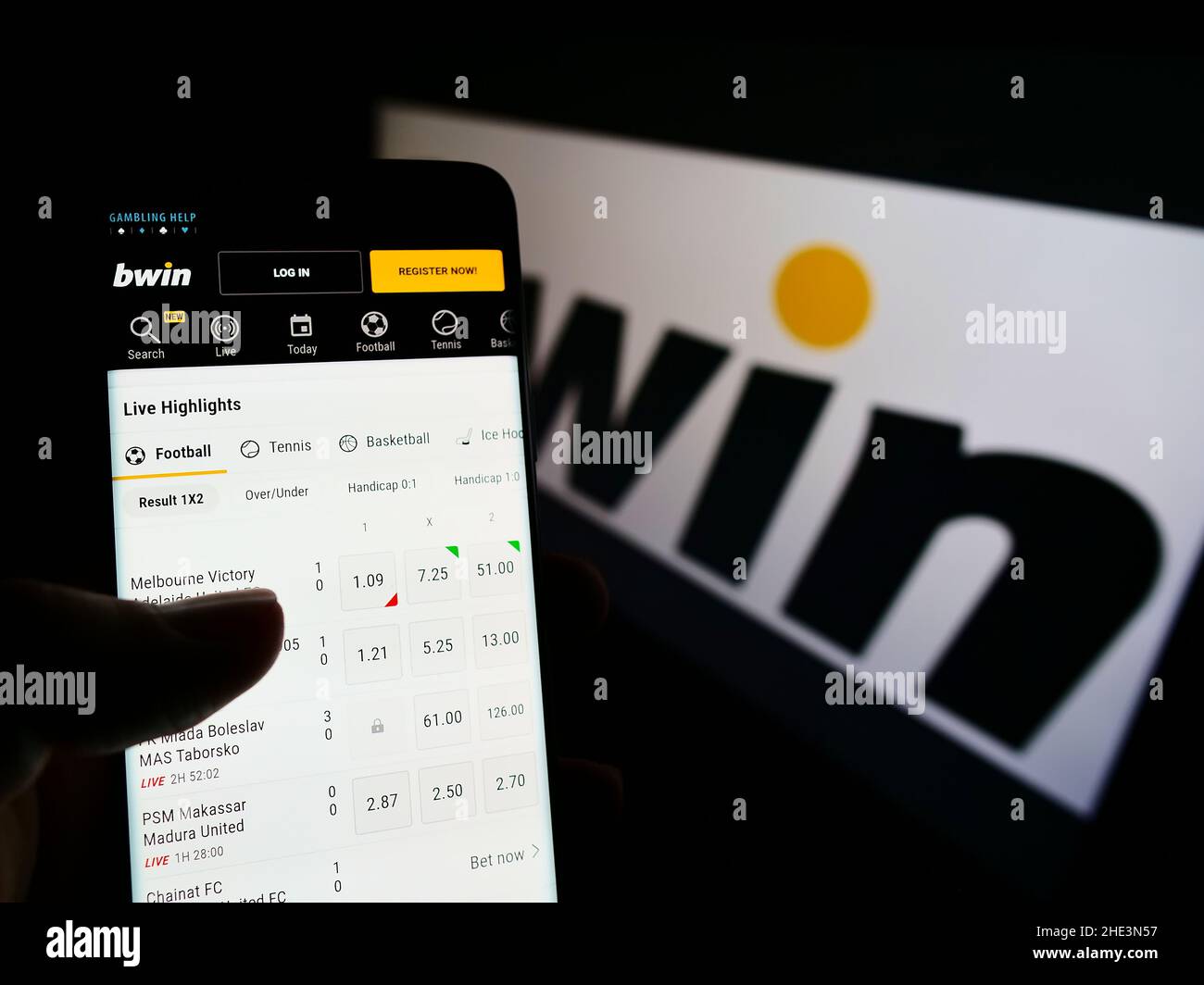 Person holding cellphone with website of Austrian company bwin Interactive Entertainment AG on screen with logo. Focus on center of phone display. Stock Photo