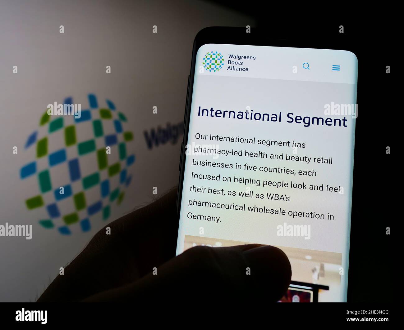 Person holding cellphone with webpage of US pharmacy company Walgreens Boots Alliance Inc. on screen with logo. Focus on center of phone display. Stock Photo