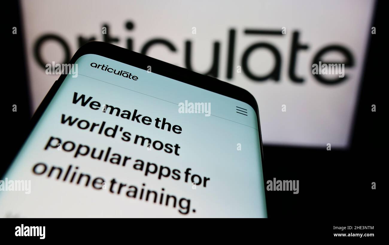 Smartphone with website of US e-learning company Articulate Global LLC on screen in front of business logo. Focus on top-left of phone display. Stock Photo