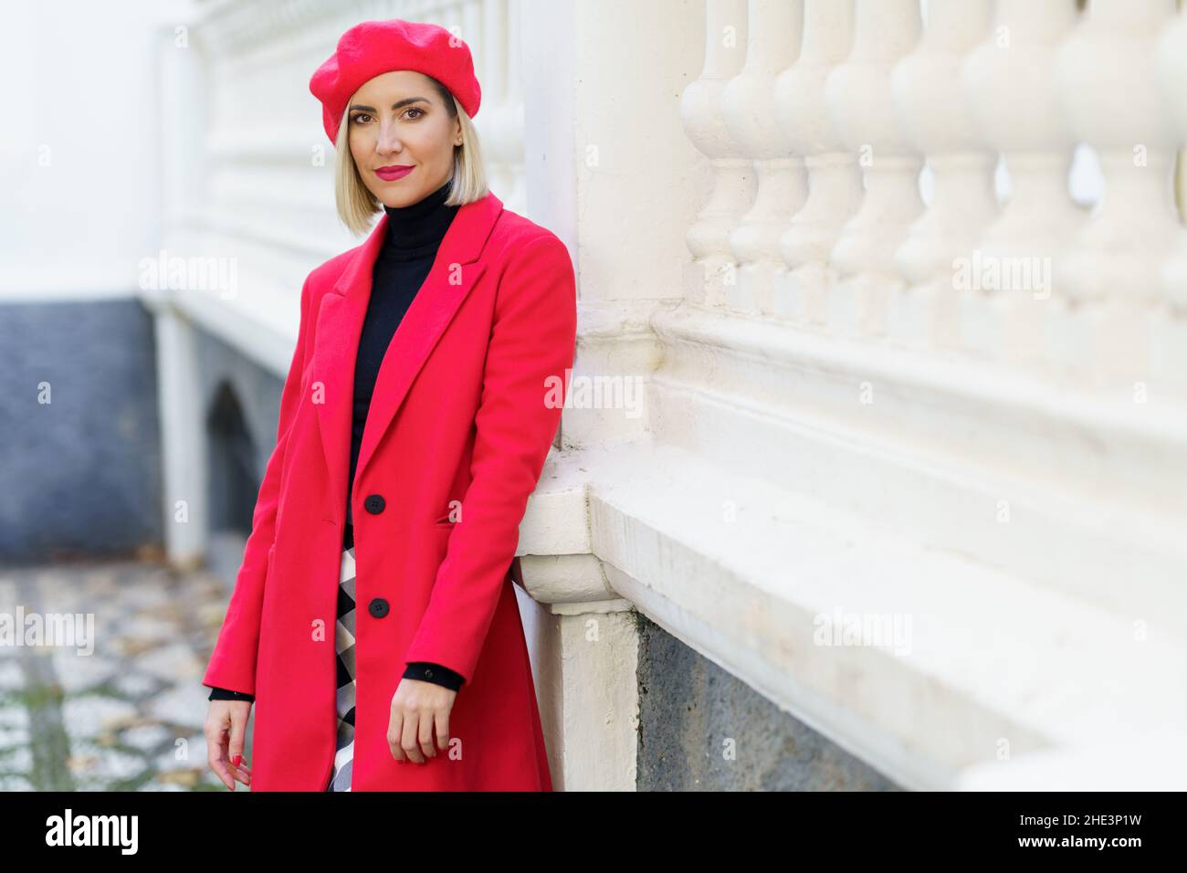 Beautiful middle-aged woman wearing red winter clothes posing looking at camera. Stock Photo