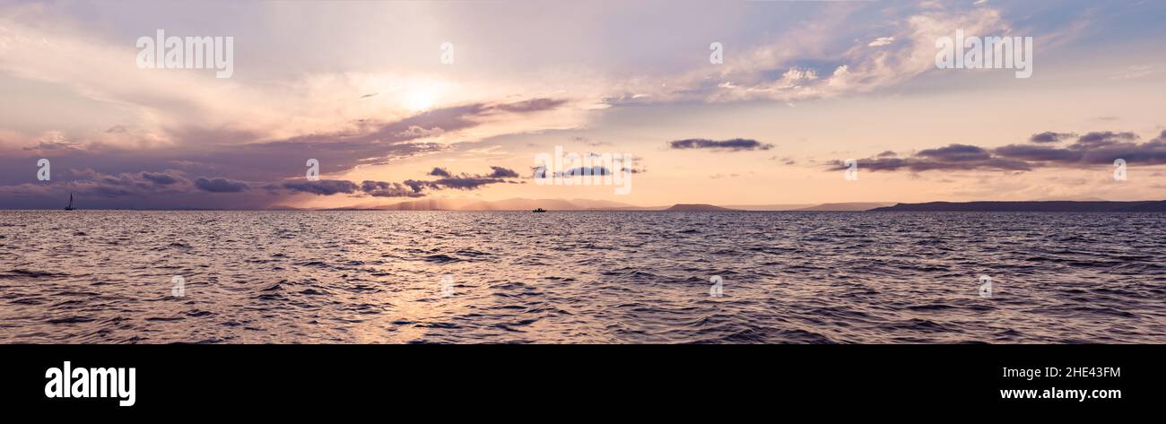 Beautiful sunset over sea with reflection in water, majestic clouds in ...