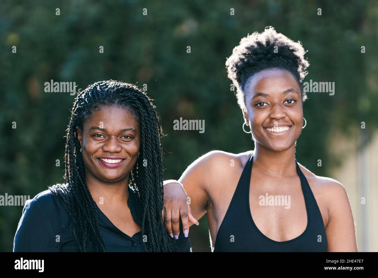 Two youth african women smiling to the camera in a park Stock Photo
