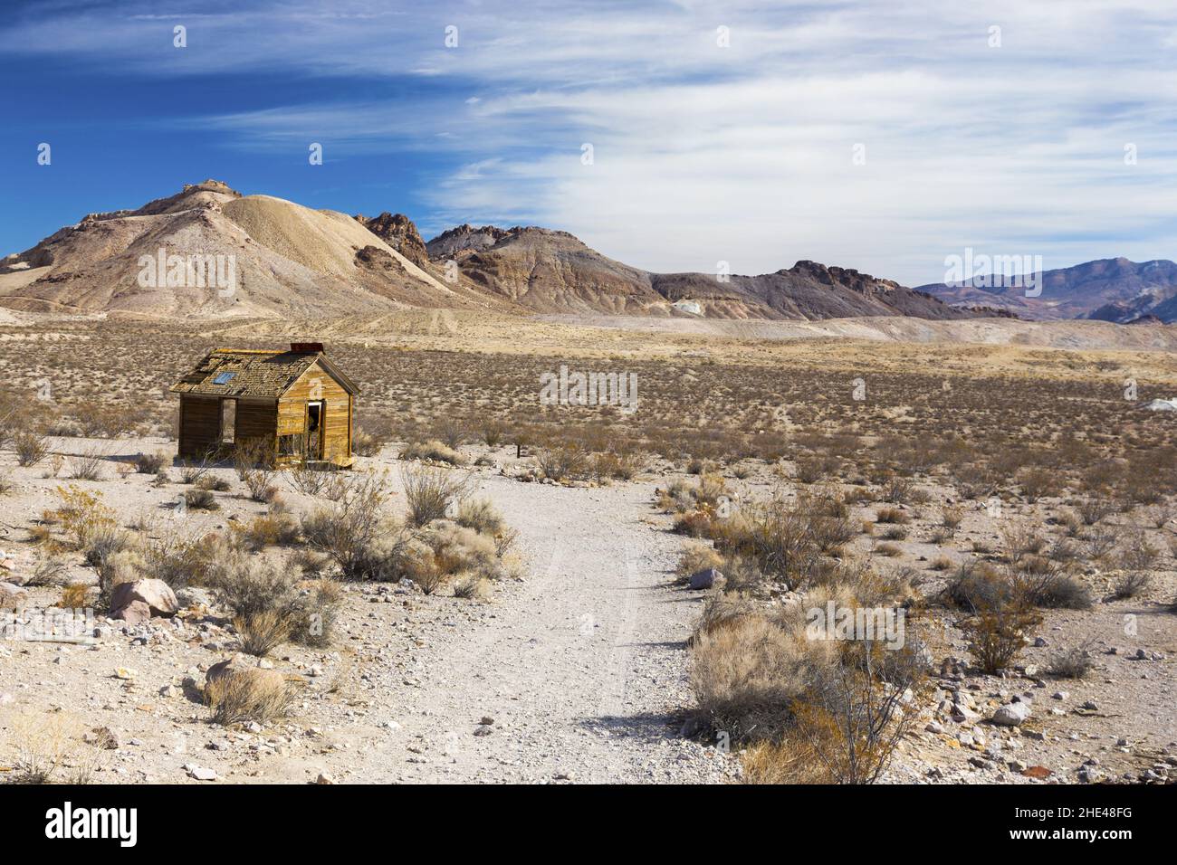 Isolated Ruins Old Wooden Vintage Log Cabin Scenic Desert Landscape Distant Mountain Peaks. Historical Rhyolite Ghost Town Death Valley National Park Stock Photo