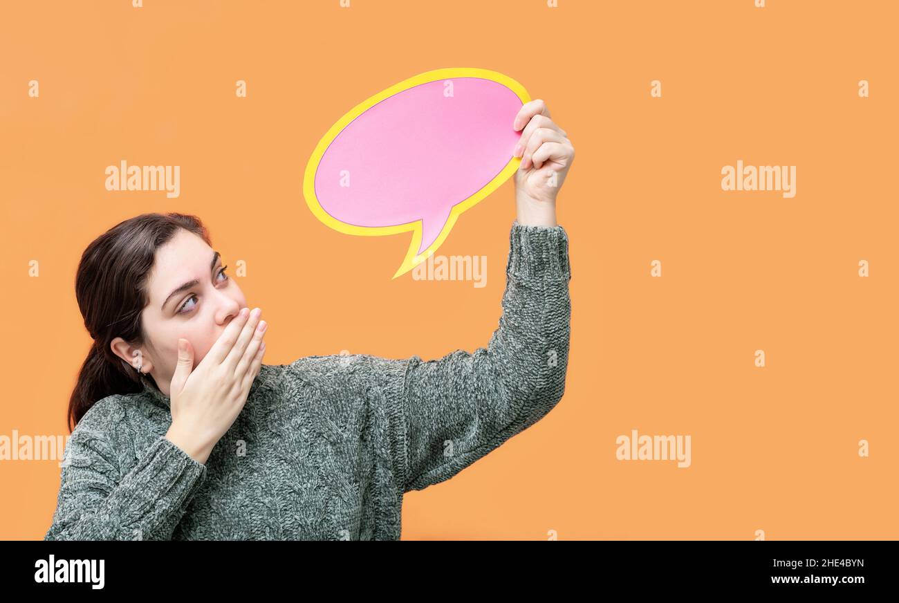 Surprised caucasian woman with speech balloon, isolated on orange background. Stock Photo