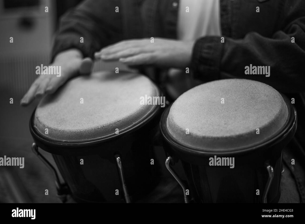 A young guy with a beard plays percussion bongos Stock Photo Alamy