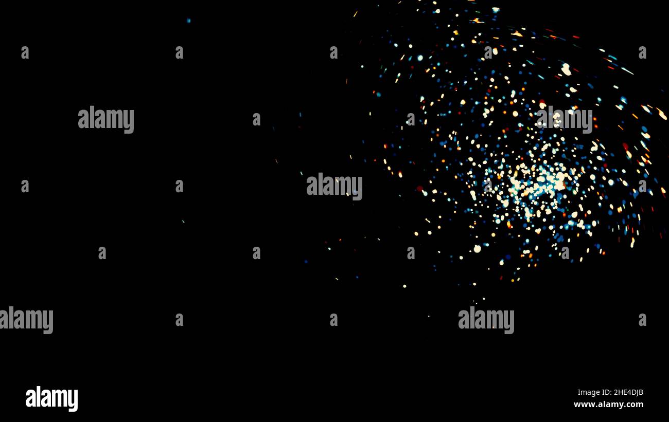 Abstract colorful glitter particles spreading fast on black background ...