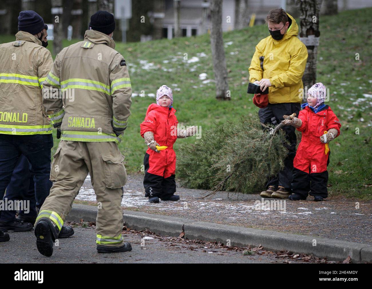 Richmond, Canada. 8th Jan, 2022. People hand a tree to firefighters during  the annual Christmas tree chipping event in Richmond, British Columbia,  Canada, on Jan. 8, 2022. Firefighters volunteered to help residents