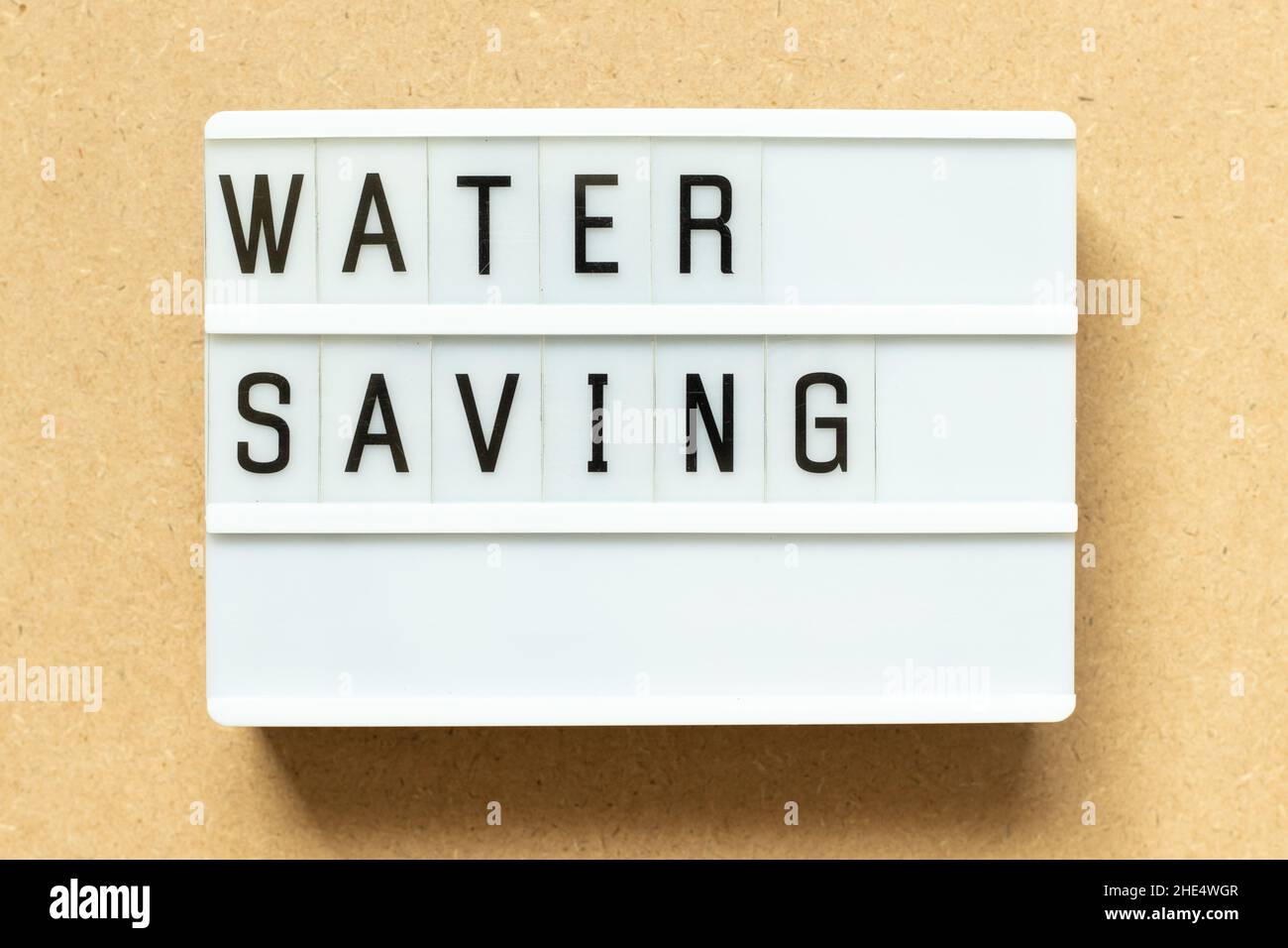 Lightbox with word water saving on wood background Stock Photo