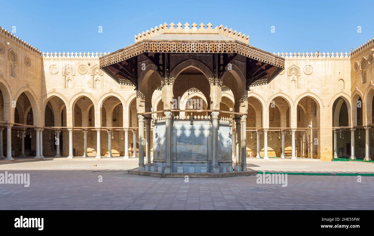 Ablution fountain mediating the courtyard of public historic mosque of Sultan al Muayyad, with background of arched corridors surrounding the courtyard, Cairo, Egypt Stock Photo