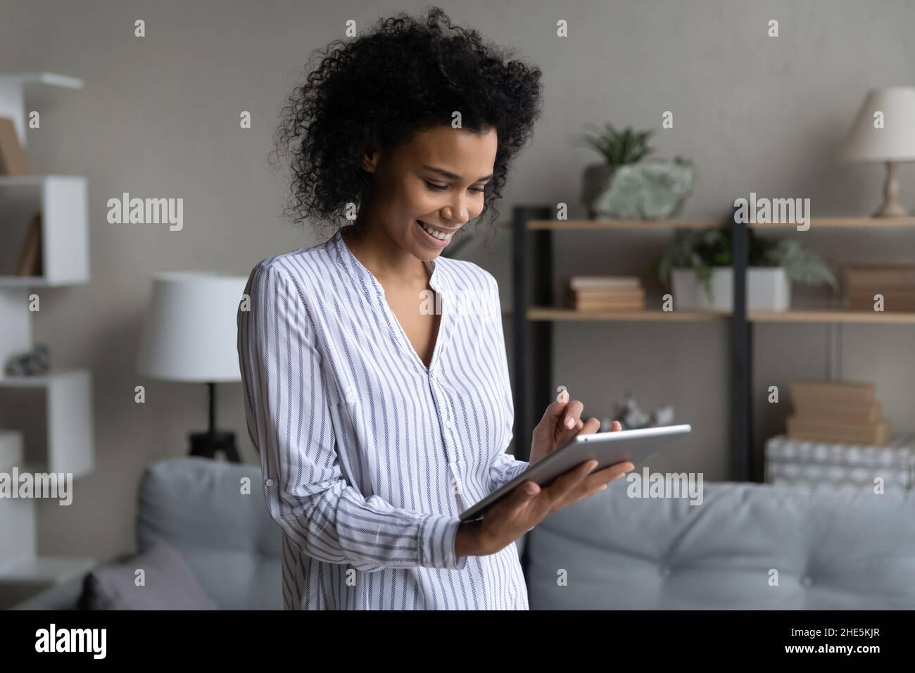 Happy millennial african ethnic woman using digital computer tablet ...