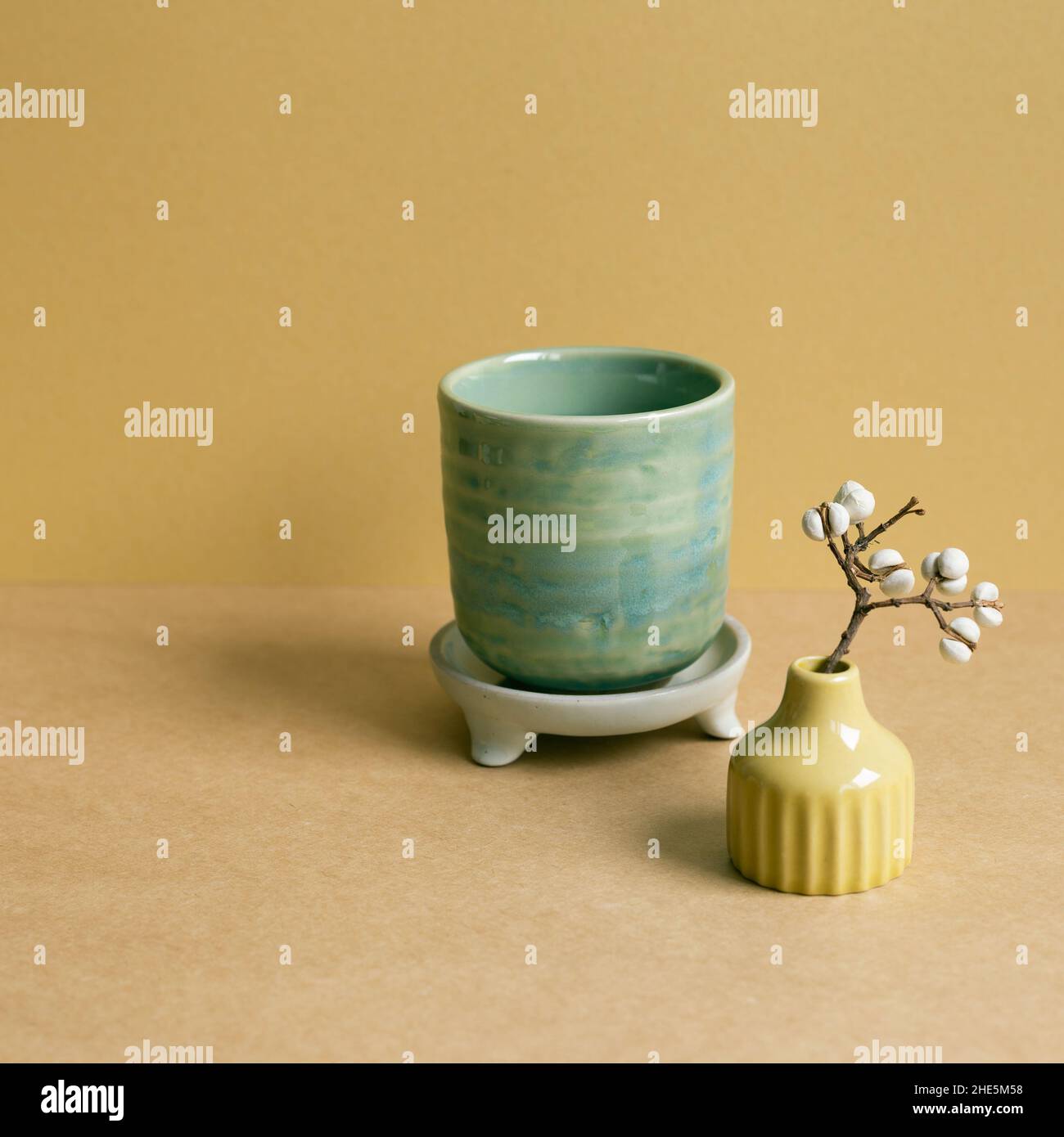 Ceramic tea cup with dry plant on brown table background Stock Photo