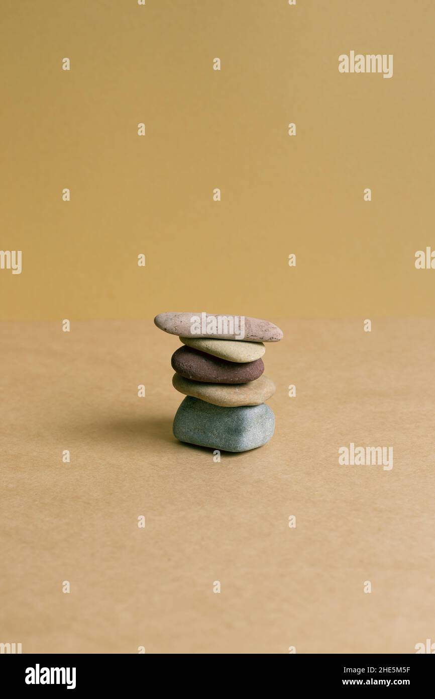 Stack of pebble stones on brown table background Stock Photo