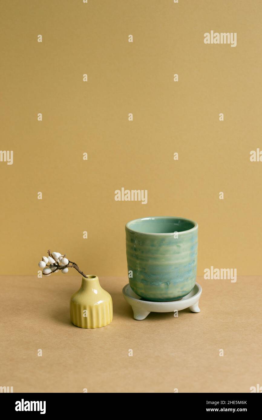 Ceramic tea cup with dry plant on brown table background Stock Photo