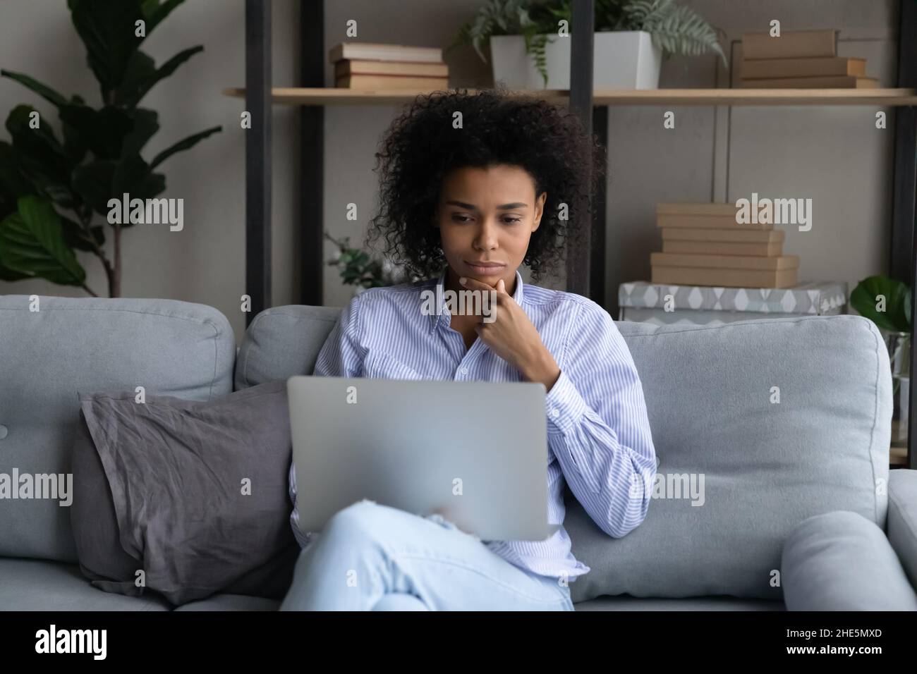 Thoughtful young african american woman using computer. Stock Photo