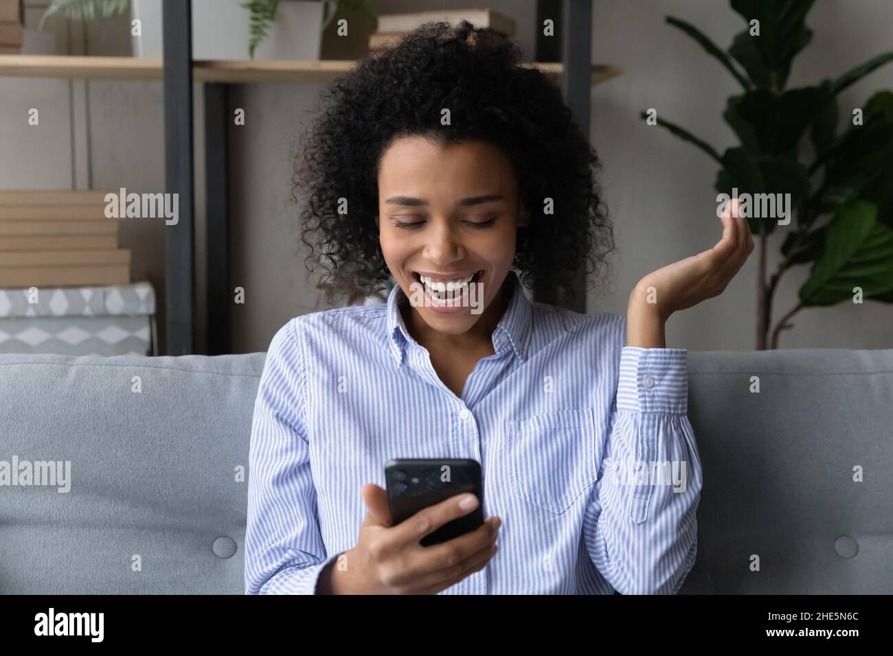 Happy young african american woman celebrating success Stock Photo - Alamy