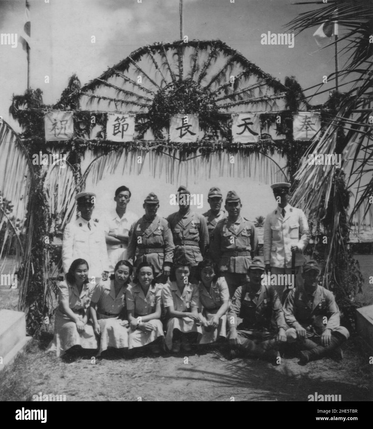 Pacific War, 1941-1945. Sailors and civil officers of the Imperial Japanese Navy and Indonesian locals gather to celebrate the birthday of Emperor Hirohito in Japanese-occupied Celebes, Dutch East Indies, April 29th, circa 1942. Stock Photo