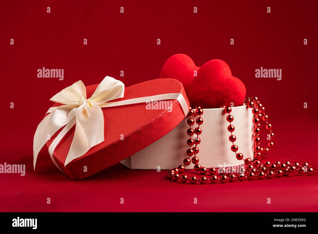 gift box in the form of a heart on a red background with hearts and ...