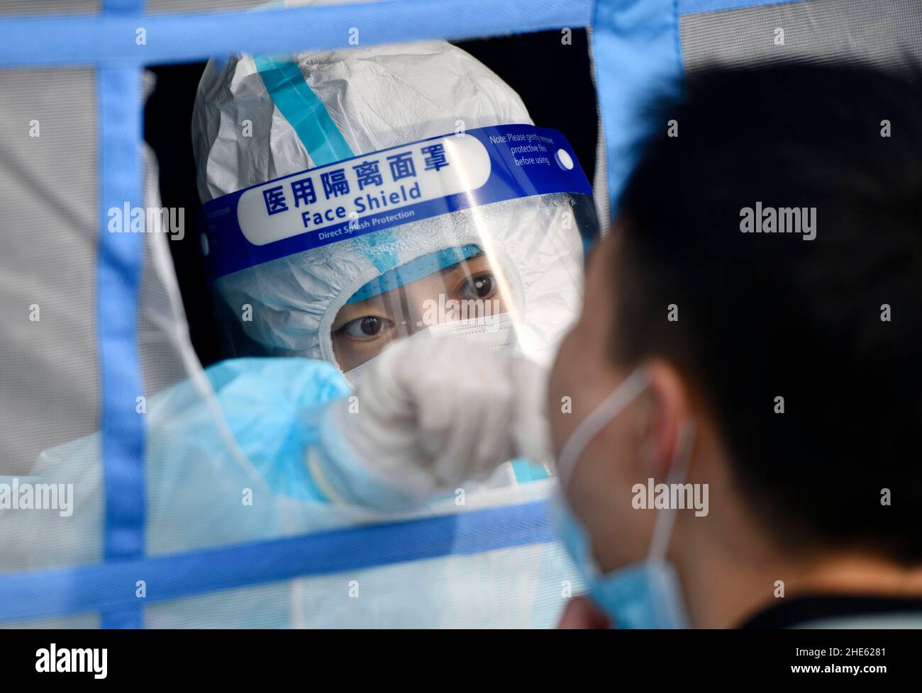 Tianjin, China. 09th Jan, 2022. A medical worker takes a swab sample from a citizen for nucleic acid test at a testing site in Binhai New Area in north China's Tianjin, Jan. 9, 2022. North China's Tianjin, a municipality that neighbors Beijing, has decided to start a citywide nucleic acid testing after 20 people tested positive for COVID-19, authorities said Sunday. The infections were reported from 6 p.m. Friday to 9 p.m. Saturday in Jinnan District, and the gene sequencing found the first two locally transmitted confirmed cases were infected with the VOC/Omicron variant, acco Credit: Xinhua/ Stock Photo