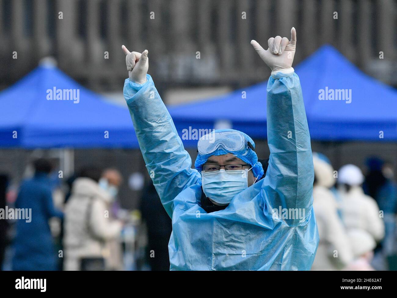 Tianjin, China. 09th Jan, 2022. A staff member gestures for citizens to line up at a designated passageway for nucleic acid test at a testing site in Nankai District in north China's Tianjin, Jan. 9, 2022. North China's Tianjin, a municipality that neighbors Beijing, has decided to start a citywide nucleic acid testing after 20 people tested positive for COVID-19, authorities said Sunday. The infections were reported from 6 p.m. Friday to 9 p.m. Saturday in Jinnan District, and the gene sequencing found the first two locally transmitted confirmed cases were infected with the VO Credit: Xinhua/ Stock Photo