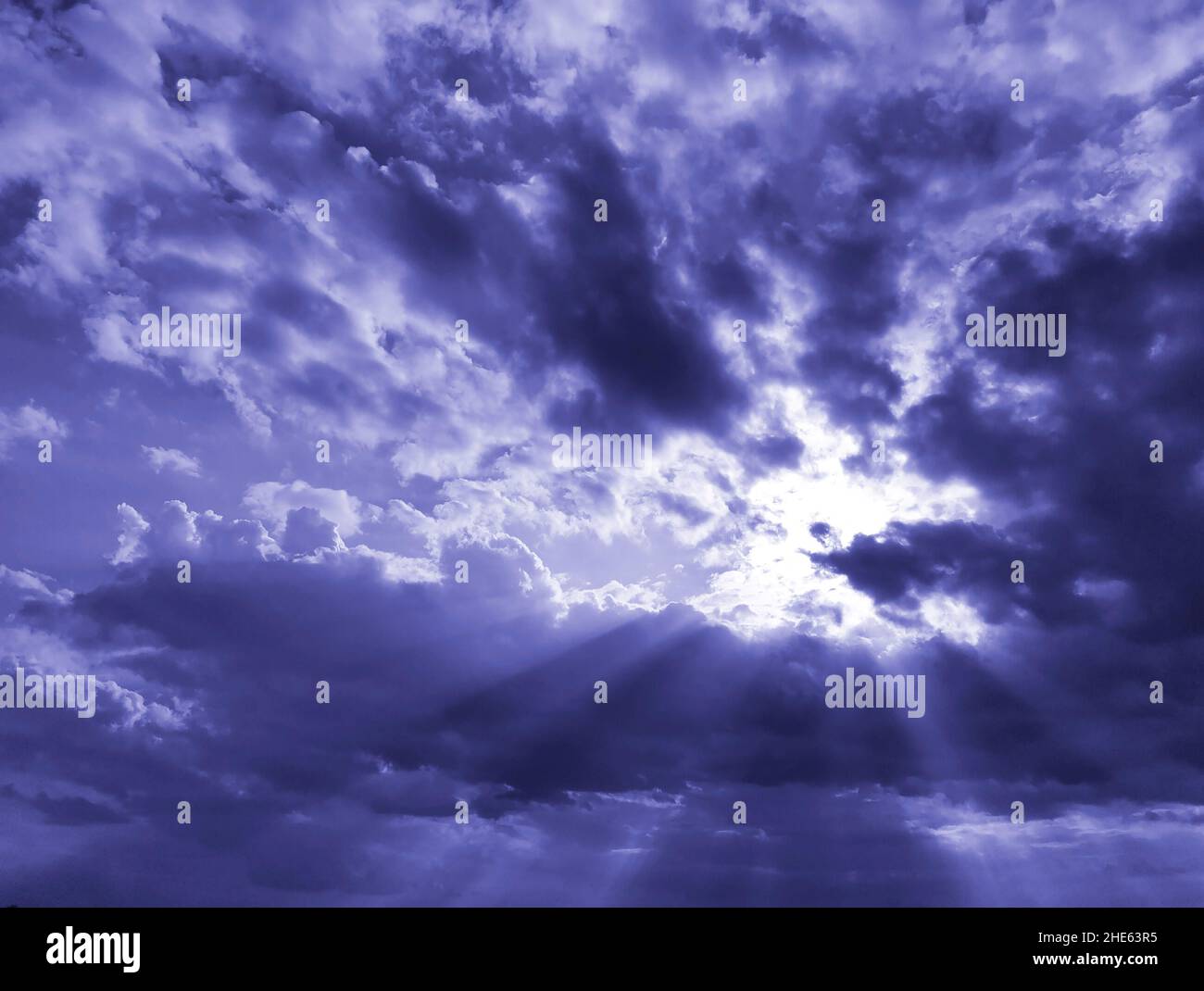 Rays of sun breaking through dark majestic clouds in sky. Trendy toning ...