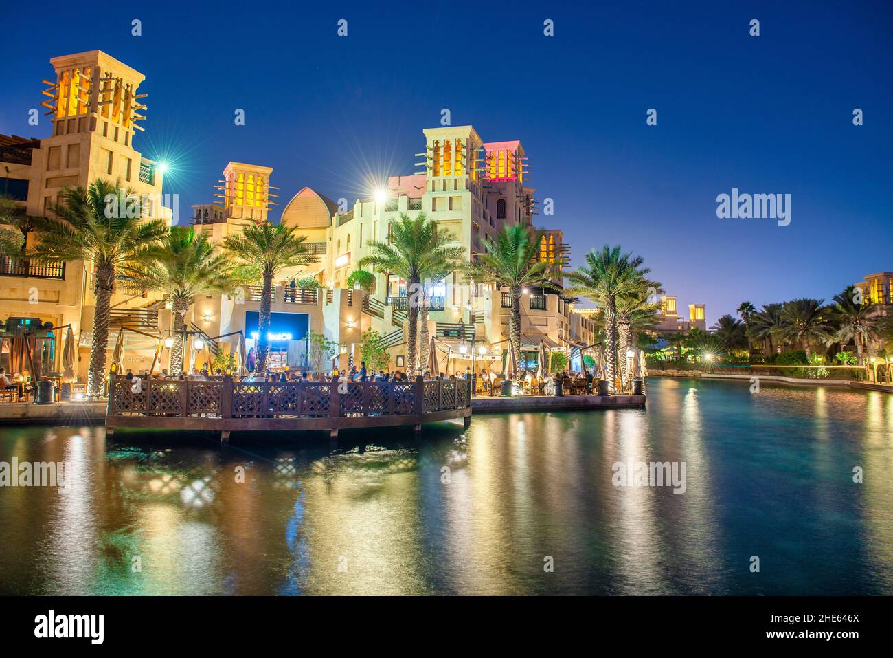 DUBAI, UAE - DECEMBER 9, 2016: Madinat Jumeirah buildings and tourists along the canals at night Stock Photo