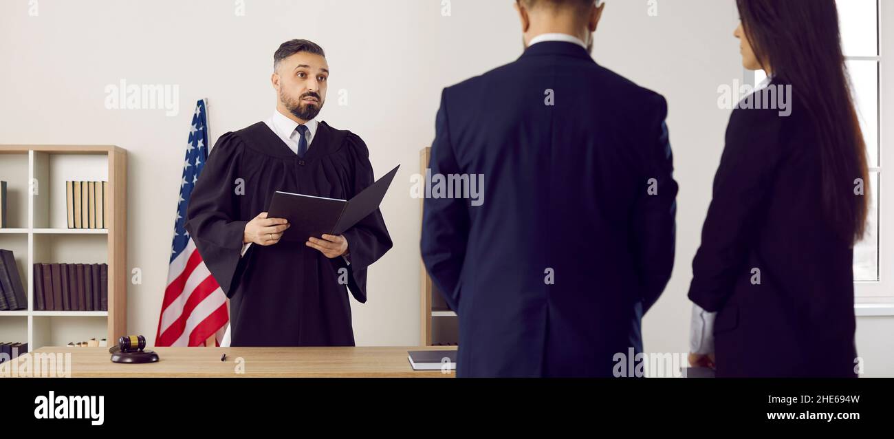 Lawyer and defendant in American courthouse listening to judge who is