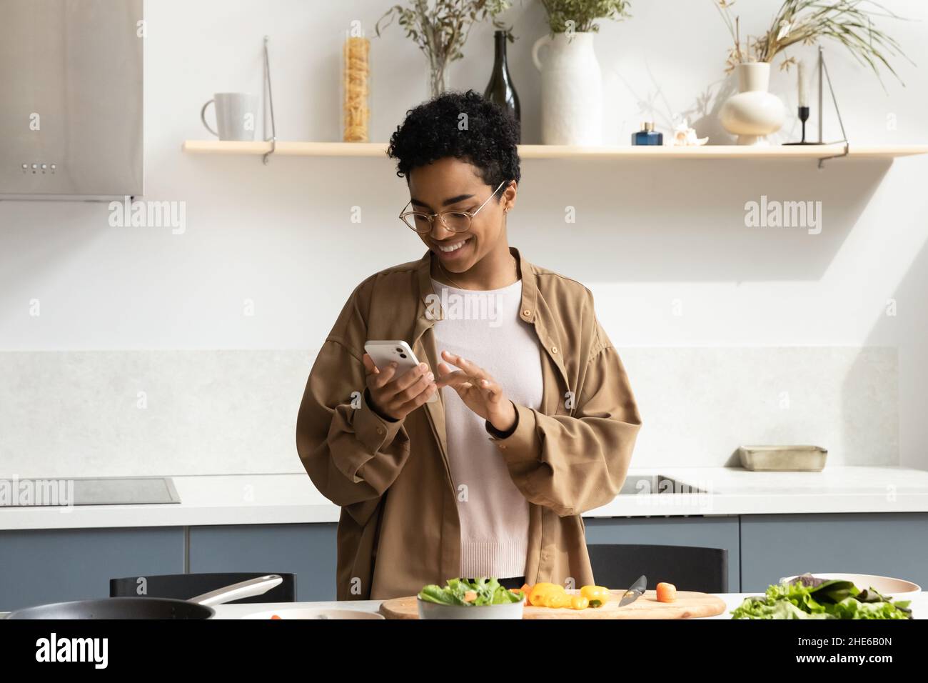Happy African chef girl cooking in home kitchen Stock Photo