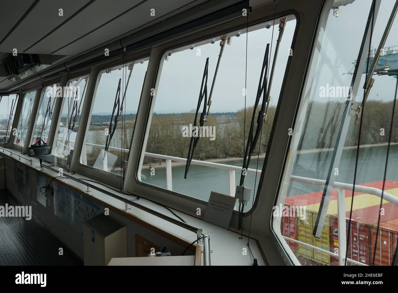View from front windows with windscreen wipers of navigational bridge of container vessel. Stock Photo