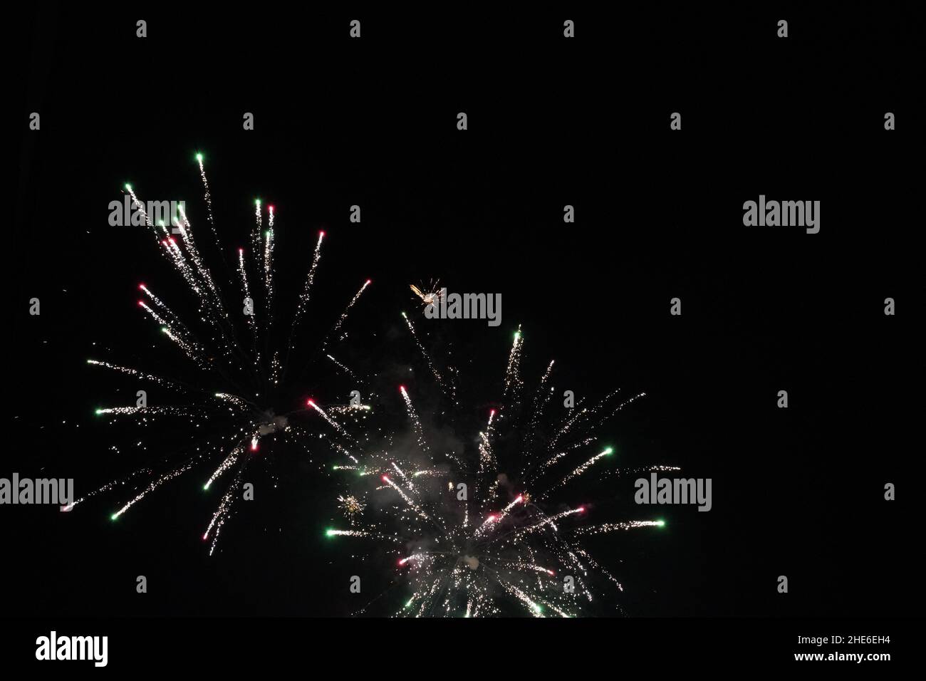 Exploding fireworks on black sky as background at midnight as part of celebration of new year or other festivals. Stock Photo