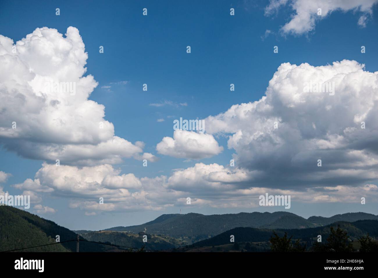 Bright blue sky and thick layer of white fluffy clouds floating above ...