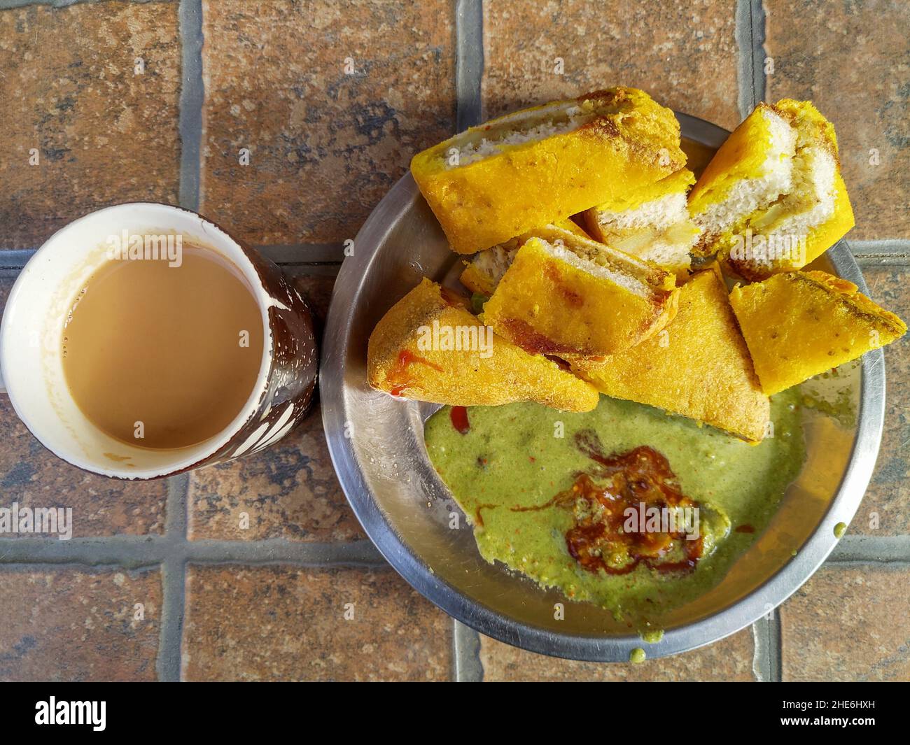 A plate of fried bread filled with messed potatoes also called as bread pakoda in INDIA. It is served with green chilli chutney and red sauce. Stock Photo