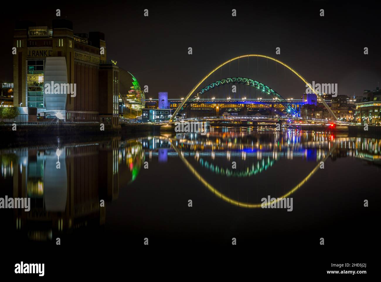 The bridges over the river Tyne at night reflecting in the water, in Newcastle England Stock Photo