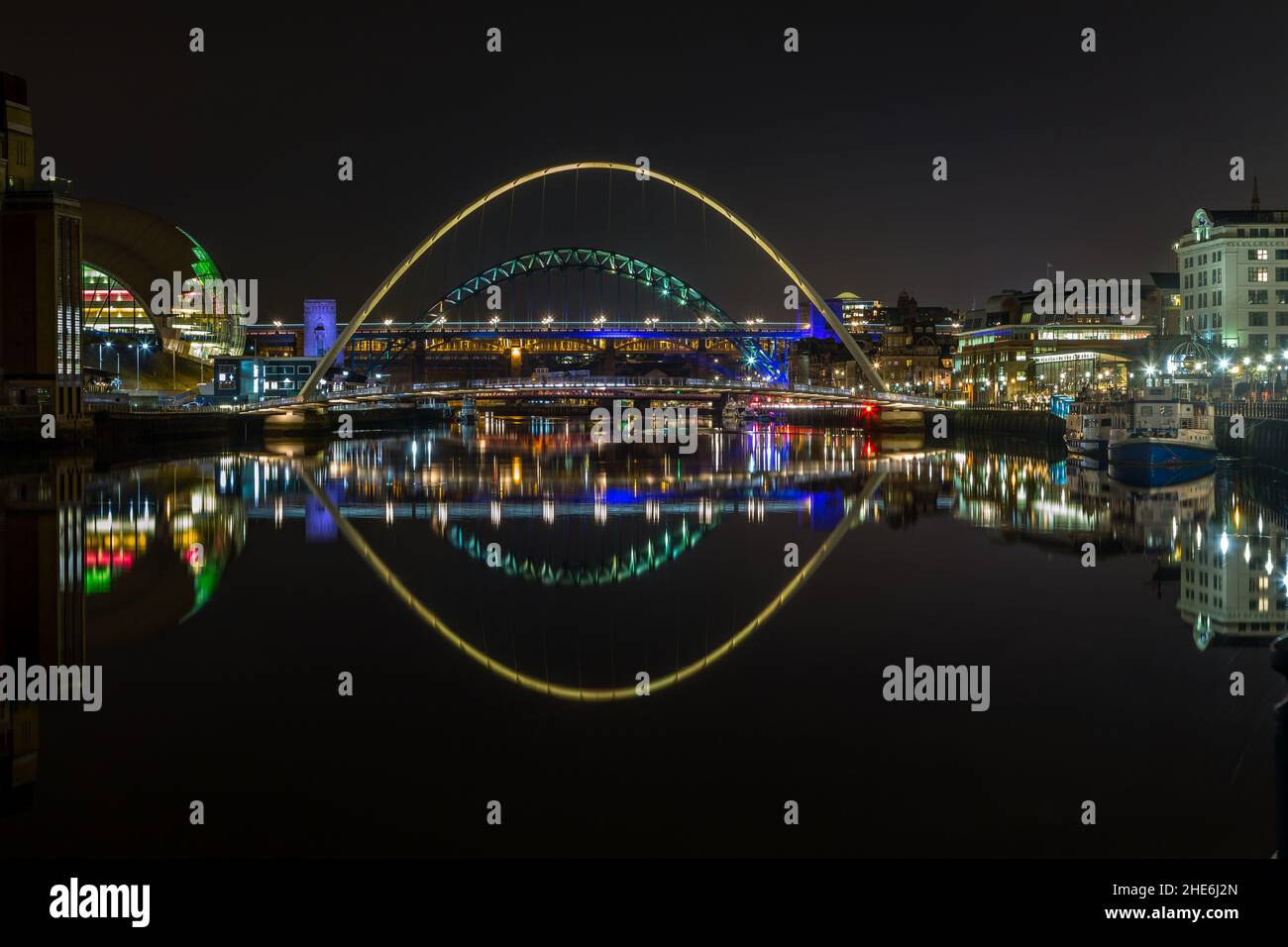 The bridges over the river Tyne at night reflecting in the water, in ...