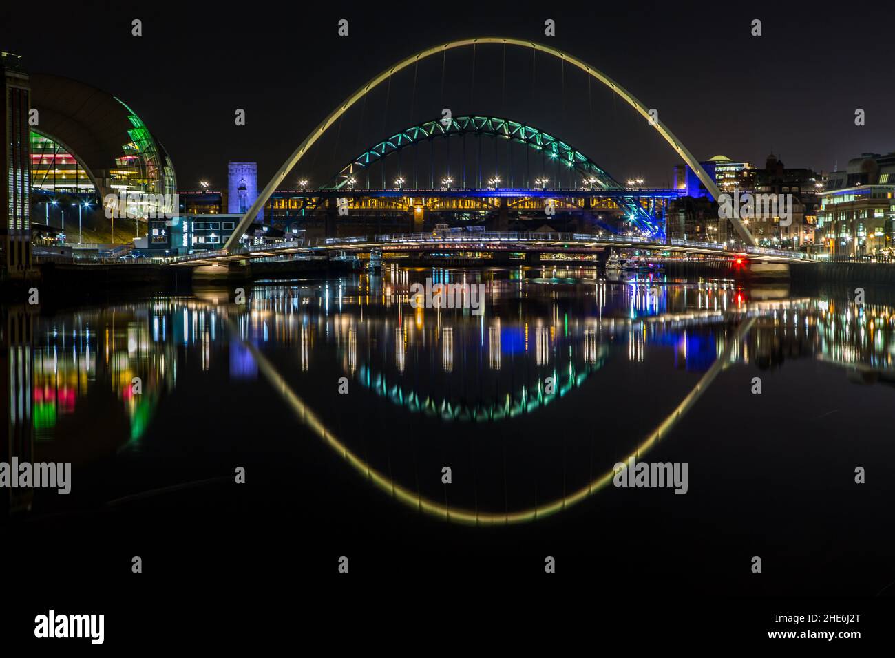 The bridges over the river Tyne at night reflecting in the water, in Newcastle England Stock Photo
