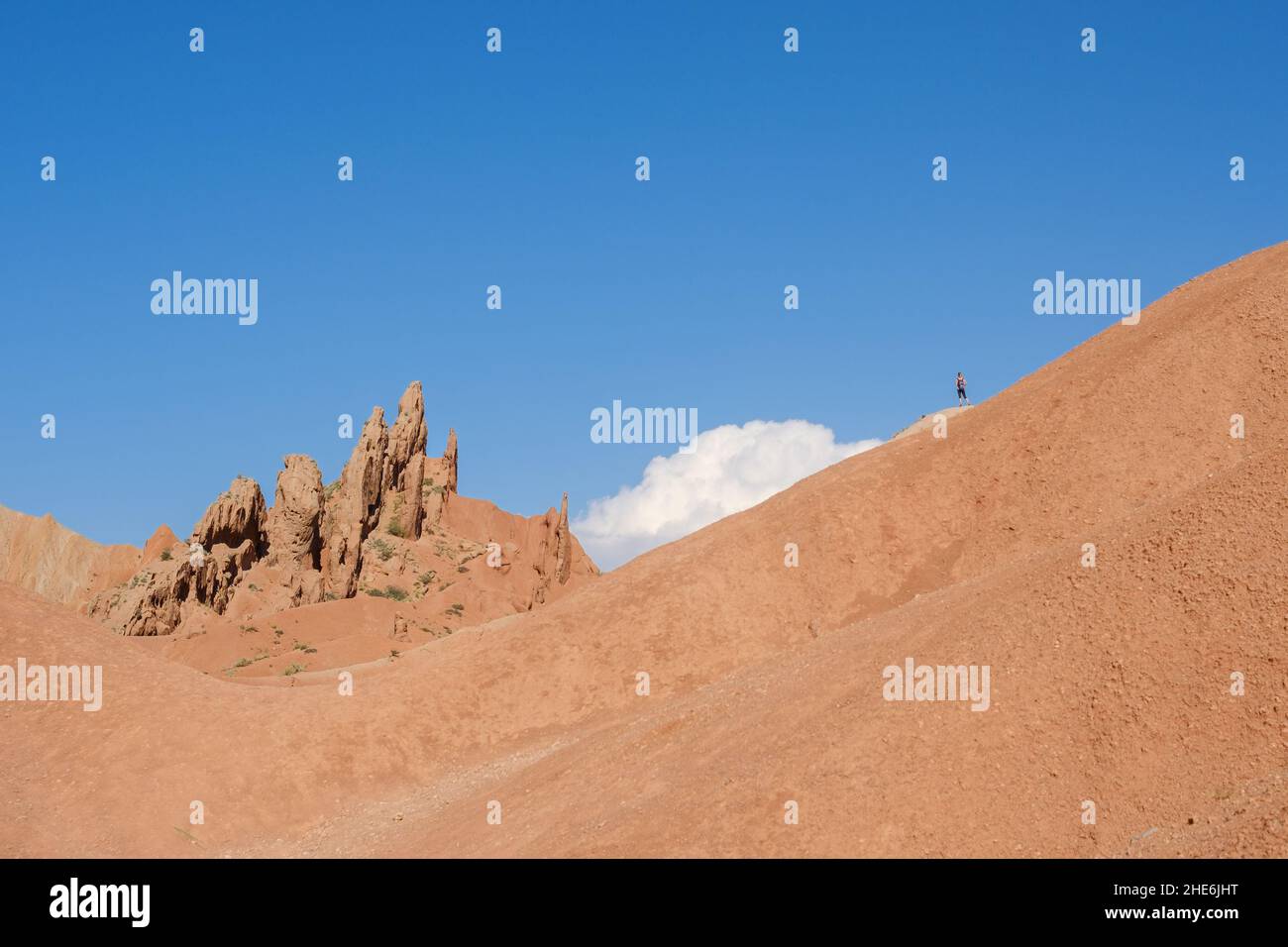 Woman standing on a hill in the Skazka fairytale canyon close to lake Issyk-Kul, Tosor, Kyrgyzstan Stock Photo