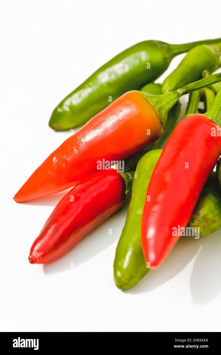 Red and green chilies, against white background, close-up Stock Photo